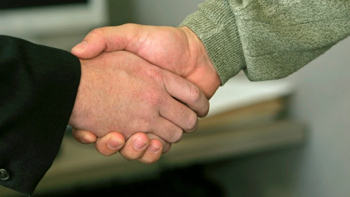 a close up of two people shaking hands